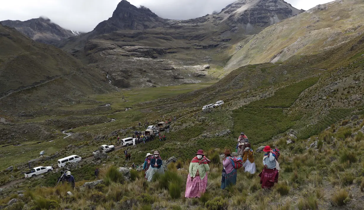 Wanita Aymara mendaki gunung untuk melihat dua burung kondor Andes dilepaskan ke alam liar di pinggiran Choquekhota, Bolivia, Selasa (23/2/2021). Pelepasliaran dua burung kondor Bolivia yang terancam punah ini bagian dari proyek di bawah naungan program konservasi negara. (AP Photo/Juan Karita)