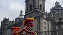 Kerangka naik sepeda dipamerkan di depan Katedral Metropolitan saat pameran Fridacraneos, tengkorak raksasa yang dilukis untuk menghormati mendiang seniman Meksiko Frida Kahlo, sebagai bagian dari perayaan Hari Kematian di Monumen Revolusi, Mexico City, Meksiko, 29 Oktober 2021. (Claudio CRUZ/AFP)