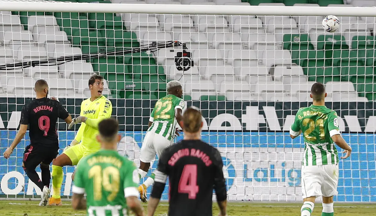 Pemain Real Madrid Karim Benzema (kiri) mencetak gol ke gawang Real Betis pada pertandingan La Liga di Stadion Benito Villamarin, Seville, Spanyol, Sabtu (26/9/2020). Real Madrid mengalahkan Real Betis 3-2. (AP Photo/Angel Fernandez)
