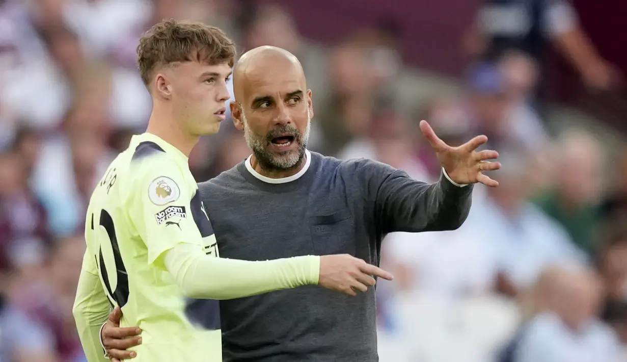 Pelatih Manchester City, Pep Guardiola menginstruksikan Cole Palmer saat bertanding melawan West Ham pada pertandingan pembuka Liga Inggris 2022/2023 di Stadion London di London, Inggris, Senin (8/8/2022). City menang atas West Ham 2-0.  (AP Photo/Frank Augstein)