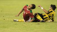Gelandang Indonesia, Andik Vermansah, dijatuhkan bek sayap Malaysia, Mohd Azrif Nasrulhaq. Pada laga itu wasit mengeluarkan dua kartu kuning untuk pemain Malaysia. (Bola.com/Vitalis Yogi Trisna)