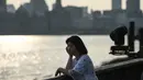 Seorang gadis melihat Sungai Huangpu di distrik keuangan Lujiazui di kota Shanghai (15/7/2019). Sungai Huangpu  secara harfiah bermakna "Sungai Tepi Sungai Kuning" adalah sebuah sungai sepanjang 97 kilometer di Republik Rakyat Tiongkok yang mengalir melalui Shanghai. (AFP Photo/Hector Retamal)