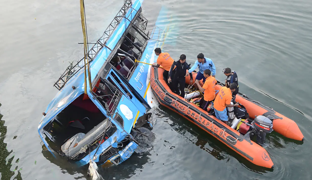 Polisi India mencari korban yang diduga masih terjebak di dalam bus yang terjun ke Sungai Bhairav, negara bagian Bengal Barat, Senin (29/1). Sedikitnya 36 orang dilaporkan tewas  dalam kecelakaan bus tersebut. (AFP Photo)