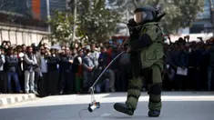  Seorang anggota tim penjinak bom membawa benda mencurigakan yang menghebohkan warga di kompleks kantor Singha Durbar, Kathmandu , Nepal, (1/3). Warga sekitar mendadak heboh karena mengira benda tersebut adalah sebuah bom. (REUTERS / Navesh Chitrakar)