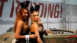 Dua orang SPG memakai topi kelinci berpose disamping mobil klasik saat pameran Essen Motor Show di Essen, Jerman, (27/11). Essen Motor Show berlangsung dari tanggal 28 November sampai 6 Desember. (REUTERS/Ina Fassbender)