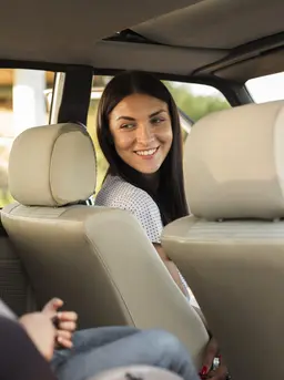 ibu memakaikan car seat untuk anaknya di mobil. credits: freepik