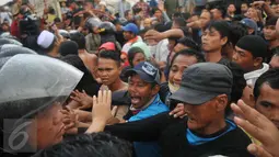 Aksi saling dorong antara petugas keamanan dan warga mewarnai penggusuran Pasar Ikan, Penjaringan, Jakarta, Senin (11/4). Penertiban diwarnai bentrokan antara petugas dan warga yang menolak penggusuran di kawasan tersebut. (Liputan6.com/Gempur M Surya)