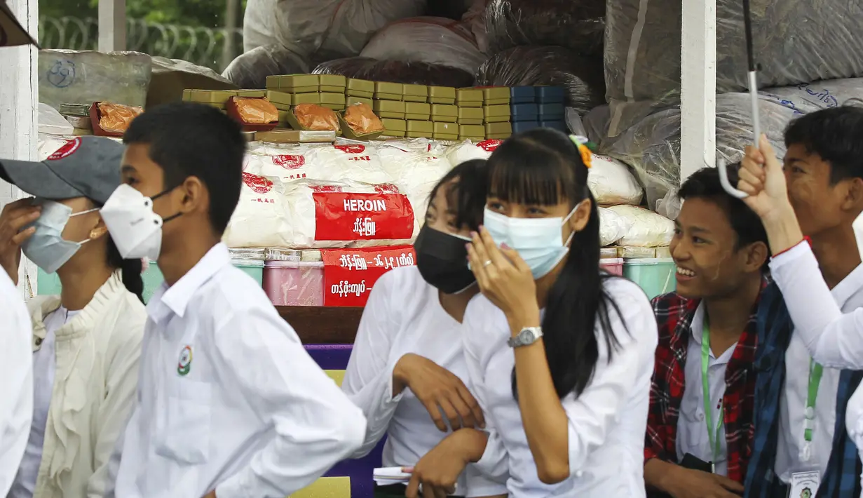 <p>Para pelajar melihat narkotika ilegal yang disita ditampilkan sebelum dimusnahkan di pinggiran Yangon, Myanmar, Minggu (26/6/2022). Pemusnahan narkotika tersebut untuk menandai Hari Internasional Menentang Penyalahgunaan Narkoba dan Perdagangan Gelap. (AP Photo/Thein Zaw)</p>