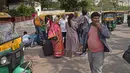 Pengemudi bajaj (kanan) berjalan menjauh dari penumpang yang menunggu transportasi saat pemogokan oleh operator transportasi swasta di New Delhi, India, 18 April 2022. Berbagai serikat pekerja bajaj dan taksi di ibu kota mogok menuntut revisi tarif setelah kenaikan harga BBM (AP Photo/Manish Swarup)