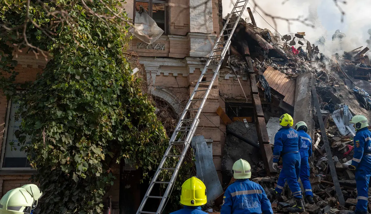 Petugas pemadam kebakaran bekerja setelah sebuah pesawat tak berawak menghantam gedung-gedung di Kyiv, Ukraina, Senin (17/10/2022).   Pesawat tak berawak menghantam sejumlah gedung ibu kota Ukraina pada Senin pagi ledakan tesebut menggema di seluruh Kyiv dan menimbulkan kepanikan sehingga orang-orang berlarian ke lokasi yang aman. (AP Photo/Roman Hrytsyna)