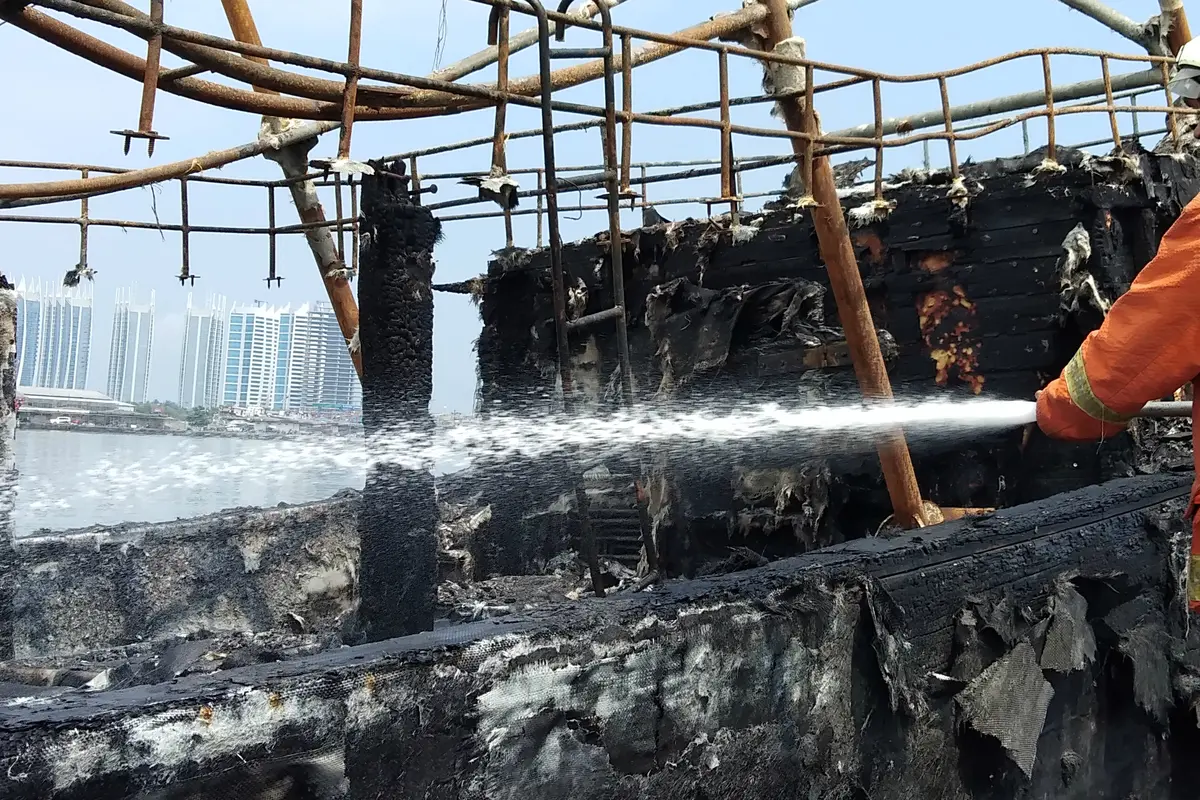 Petugas terus memadamkan kapal yang terbakar di Pelabuhan Muara Baru, Jakarta.