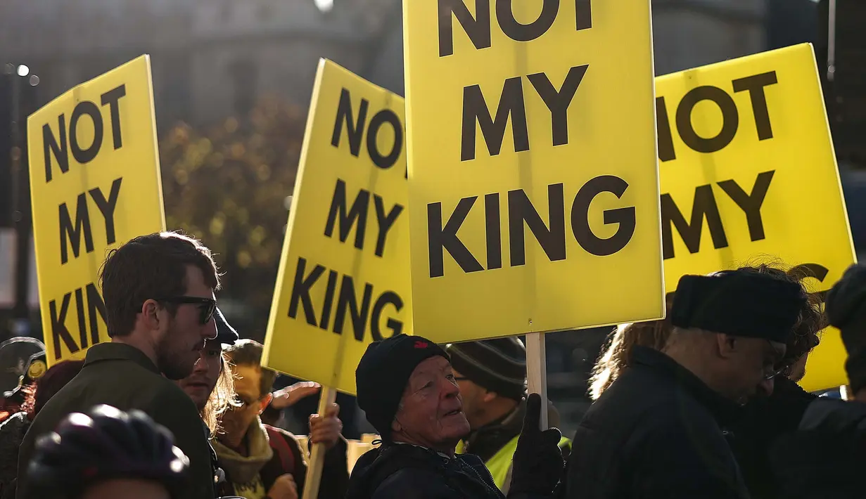 Para pengunjuk rasa memegang plakat "Not My King". (HENRY NICHOLLS/AFP)