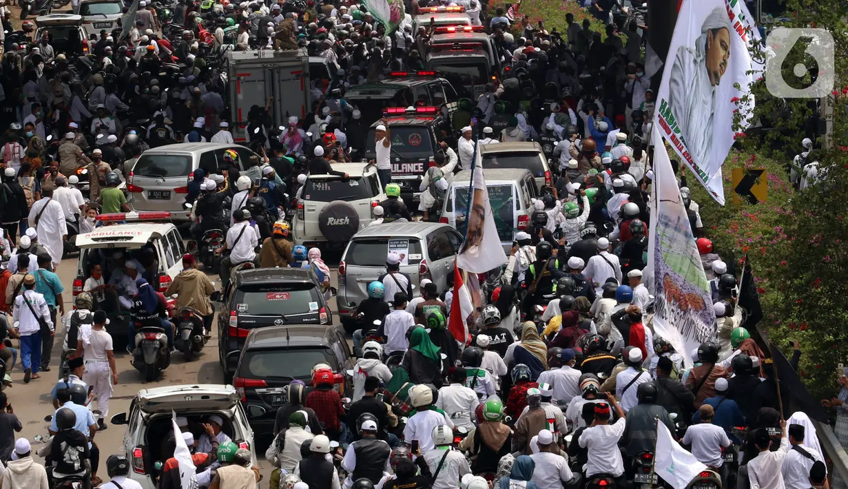 Ratusan massa berkonvoi mengawal Rizieq Shihab usai tiba di Bandara Soekarno-Hatta, Tangerang, Banten, Selasa (10/11/2020). Konvoi tersebut dilakukan untuk mengawal perjalan Rizieq Shihab menuju kediamannya di Petamburan, Jakarta. (Liputan6.com/Angga Yuniar)