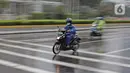 Pengendara sepeda motor menggunakan jas hujan saat berkendara di kawasan Bundaran HI, Jakarta, Minggu (24/1/2021). Kepala BMKG Dwikorita mengatakan, puncak musim hujan akan terjadi pada Januari dan Februari 2021, sehingga perlu diwaspadai terjadinya cuaca ekstrem. (Liputan6.com/Herman Zakharia)