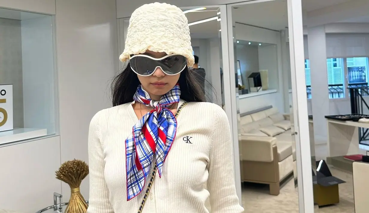 <p>Kenakan bucket hat dan cardigan putih, Jennie BLACKPINK bikin Grandma Look jadi tren. Dipadukan dengan scarf kotak-kotak sebagai dasi dan kacamata ski. [@jennierubyjane]</p>