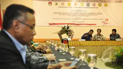 Ketua Komisi Pemilihan Umum (KPU) RI Husni Kamil Manik (kanan) berbincang dengan sejumlah anggota KPU disela acara penandatanganan MoU antara KPU RI dengan sembilan perguruan tinggi di Gedung KPU, Jakarta, Kamis (12/3/2015). (Liputan6.com/Faizal Fanani)