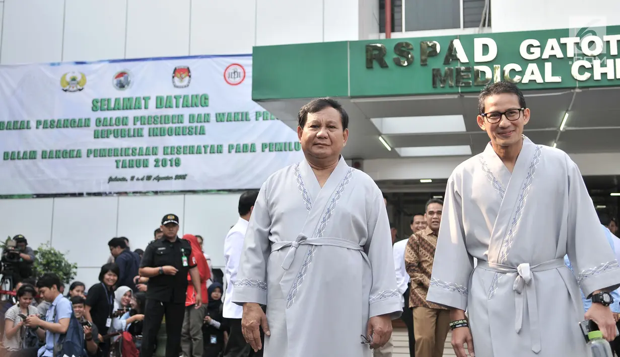 Bakal calon presiden dan wakil presiden Pilpres 2019, Prabowo Subianto (kiri) dan Sandiaga Uno menyapa awak media saat akan menjalani pemeriksaan awal tes kesehatan di RSPAD Gatot Soebroto, Jakarta, Senin (13/8). (Merdeka.com/Iqbal S. Nugroho)
