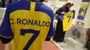 Seorang pria mengenakan kaus Cristiano Ronaldo di toko klub Al Nassr di Riyadh, Arab Saudi, Senin, 2 Januari 2023. Ronaldo dipastikan kembali mengenakan nomor 7 di Al Nassr. (AP Photo/Amr Nabil)