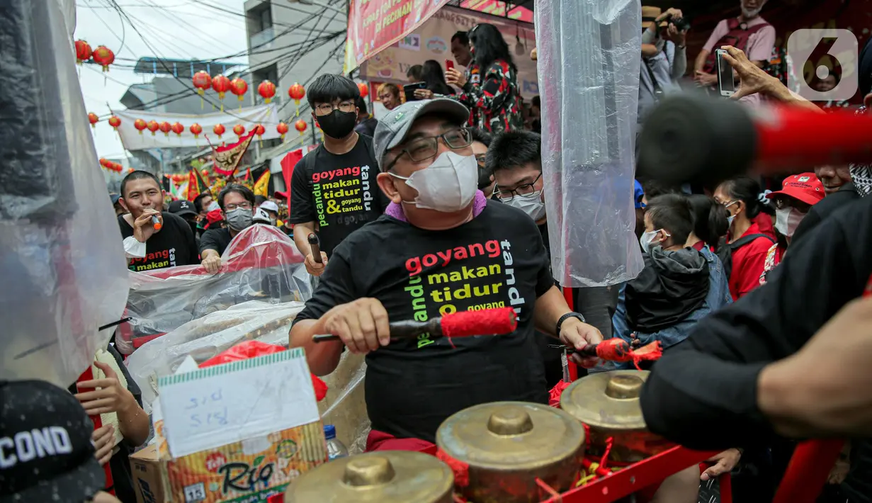 Pemusik mengiringi pawai joli atau tandu dalam Festival Cap Go Meh 2023 di kawasan Glodok, Jakarta, Minggu (5/2/2023). Sebanyak 23 joli atau tandu diarak keliling sebagai penutup rangkaian perayaan Tahun Baru Imlek yang dilaksanakan pada tanggal ke-15 bulan pertama penanggalan Tionghoa. (Liputan6.com/Faizal Fanani)