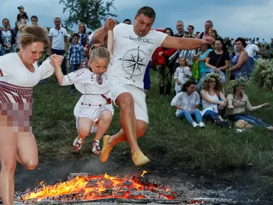 Warga melompati api unggun saat perayaan tradisional Ivan Kupala di Kiev, Ukraina, Rabu (6/7). Ivan's day merupakan tradisi pagan kuno sebagai ritual kesuburan di musim panas yang masih ada di Rusia dan Ukraina. (REUTERS/ Gleb Garanich)