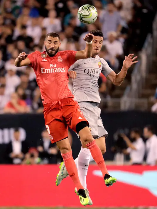 Pemain depan Real Madrid, Karim Benzema (kiri) berebut bola di udara dengan bek AS Roma Juan Jesus dalam International Champions Cup (ICC) di New Jersey, AS, Selasa (7/8). (AP Photo/Julio Cortez)