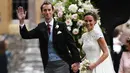 Pippa Middleton dan James Matthews setelah mengikuti upacara pernikahan di sebuah gereja kecil di Inggris, Sabtu (20/5). Pernikahan Pippa dan James disebut bagaikan royal wedding mini karena dihadiri juga keluarga Kerajaan Inggris (JUSTIN TALLIS/POOL/AFP)
