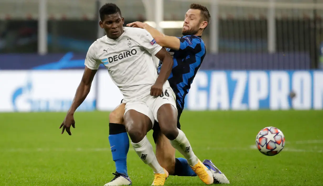 Penyerang Borussia Moenchengladbac, Breel Embolo berebut bola dengan bek Inter Milan, Stefan de Vrij pada matchday pertama Grup B Liga Champions di Giuseppe Meazza, Kamis (22/10/2020) dini hari WIB. Inter Milan harus puas bermain imbang 2-2 saat menjamu tamunya Monchengladbach. (AP Photo/Luca Bruno)
