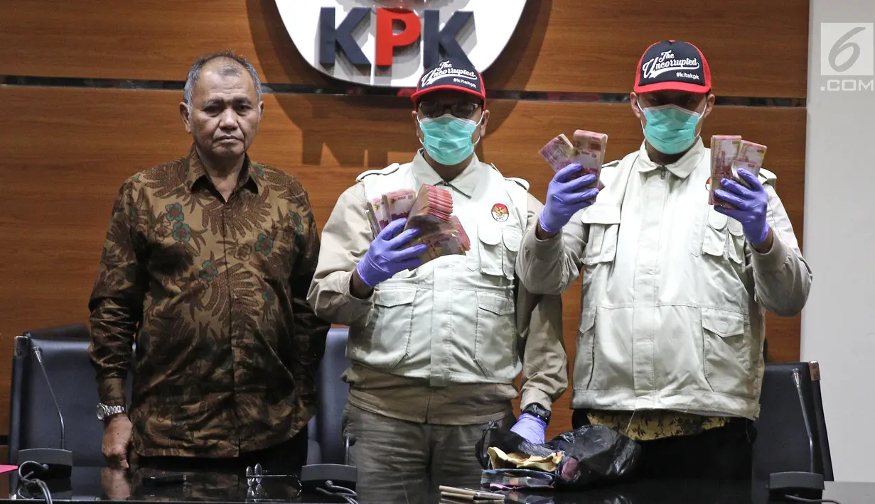 Penyidik KPK menunjukkan barang bukti uang Rp 100 juta dari OTT Bupati Purbalingga disaksikan Ketua KPK Agus Rahardjo di Gedung Merah Putih KPK, Kuningan, Jakarta, Selasa (5/6). (Liputan6.com/Herman Zakharia)