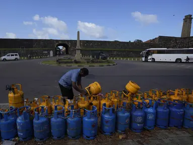 Seorang pria menggunakan gembok untuk mengamankan tabung gas memasaknya yang kosong yang ditempatkan dalam antrean mengharapkan pasokan pemerintah di Galle, Sri Lanka, Selasa (28/6/2022). Warga Sri Lanka harus mengantre panjang demi mendapatkan elpiji untuk memasak di tengah krisis yang melanda negaranya. (AP Photo/Eranga Jayawardena)