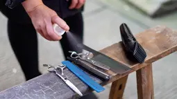 Barber sukarelawan mensterilkan peralatan cukur dengan cairan disinfektan di sebuah permukiman di Kota Chongqing, China, 16 Februari 2020. Permukiman di Distrik Beibei, Chongqing, mengoordinasikan tim barber sukarelawan untuk menyediakan jasa potong rambut gratis bagi penduduknya. (Xinhua/Liu Chan)