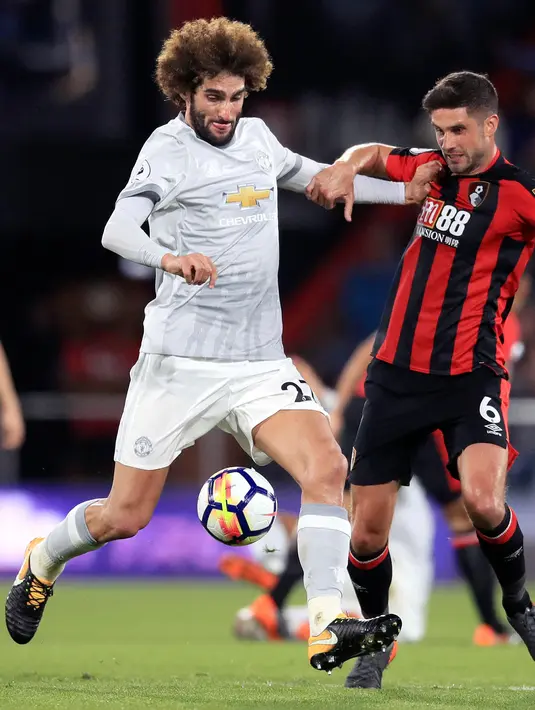 Gelandang Manchester United, Marouane Fellaini berebut bola dengan pemain Bournemouth, Andrew Surman pada pertandingan Liga Inggris di Stadion Vitality, (18/4). MU menang 2-0 atas Bournemouth. (AP Photo/Adam Davy)