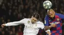 Bek Real Madrid, Sergio Ramos berebut bola udara dengan gelandang Barcelona,  Arturo Vidal pada pertandingan lanjutan La Liga Spanyol di stadion Camp Nou (18/12/2019). Barcelona bermain imbang 0-0 atas Real Madrid. (AP Photo/Emilio Morenatti)