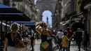 Orang-orang berjalan menyusuri jalan di depan lengkungan Rua Augusta di pusat kota Lisbon, Portugal, Senin (13/9/2021). Portugal hari ini mengakhiri aturan wajib penggunaan masker di jalan-jalan. (PATRICIA DE MELO MOREIRA / AFP)