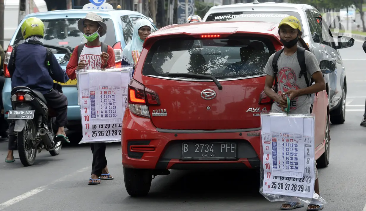 Pedagang menawarkan kalender tahun 2021 kepada pengguna jalan di perempatan Pondok Pinang, Kebayoran, Jakarta Selatan, Senin (7/12/2020). Jelang pergantian tahun, sejumlah pedangang mulai menjajakan kalender tahun 2021 dengan harga Rp 20 ribu-Rp 40 ribu tergantung ukuran. (merdeka.com/Dwi Narwoko)