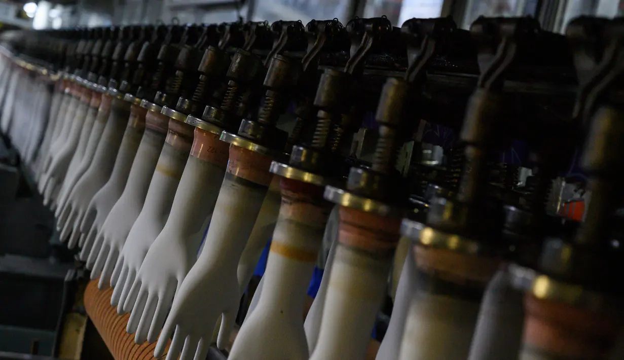 Deretan mesin sarung tangan terlihat di pabrik Top Glove di Shah Alam di pinggiran Kuala Lumpur (26/8/2020). Top Glove, sebuah perusahaan yang berbasis di Malaysia adalah salah satu produsen sarung tangan karet terbesar di dunia. (AFP/Mohd Rasfan)