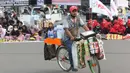 Pedagang asongan berjualan saat aksi unjuk rasa berlangsung di kawasan Patung Kuda, Jakarta, Selasa (10/11/2020). Sejumlah pedagang mencoba peruntungan saat massa gabungan dari berbagai organisasi buruh dan mahasiswa berunjuk rasa menolak Omnibus Law UU Cipta Kerja. (Liputan6.com/Helmi Fithriansyah)