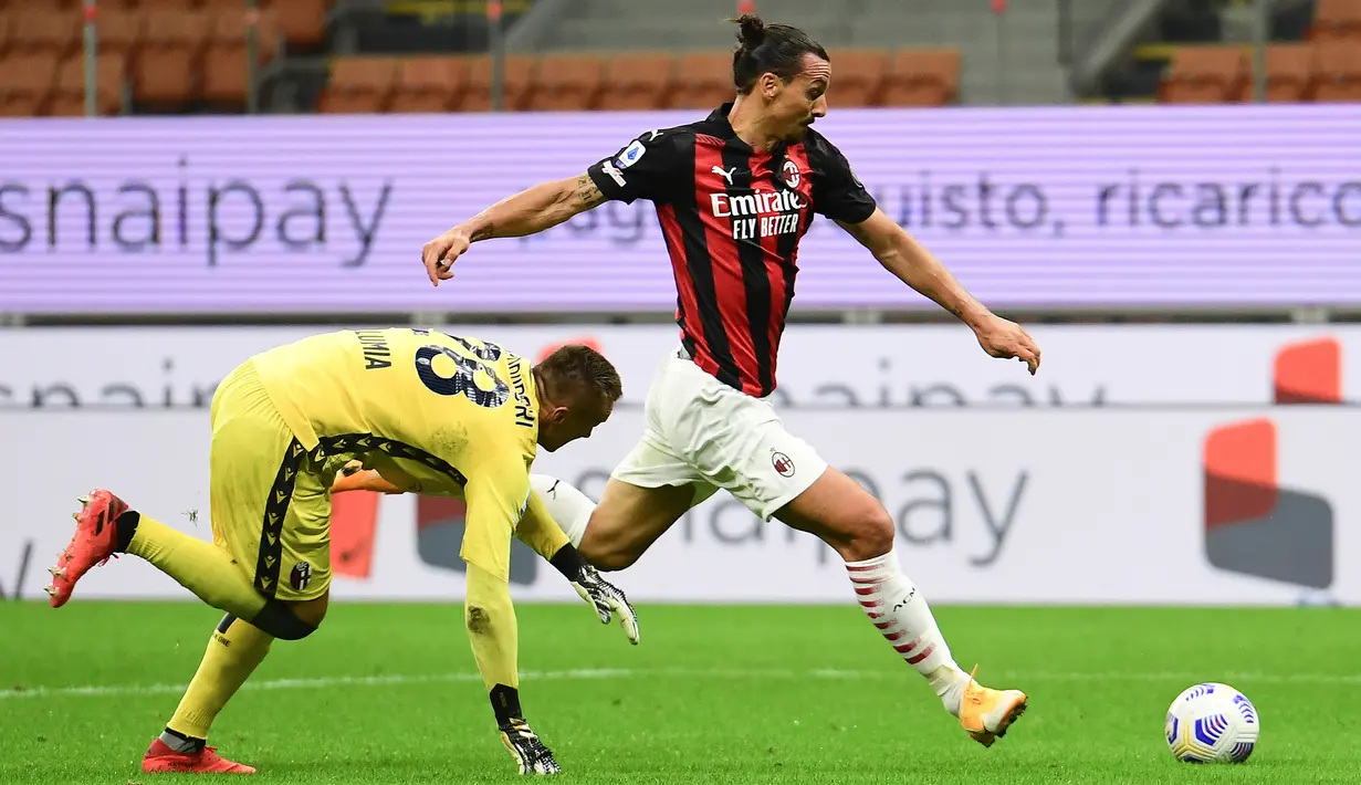 Penyerang AC Milan, Zlatan Ibrahimovic, melewati kiper Bologna, Lukasz Skorupski, pada laga Liga Italia di Stadion San Siro, Selasa (22/9/2020) dini hari WIB. AC Milan menang 2-0 atas Bologna. (AFP/Miguel Medina)