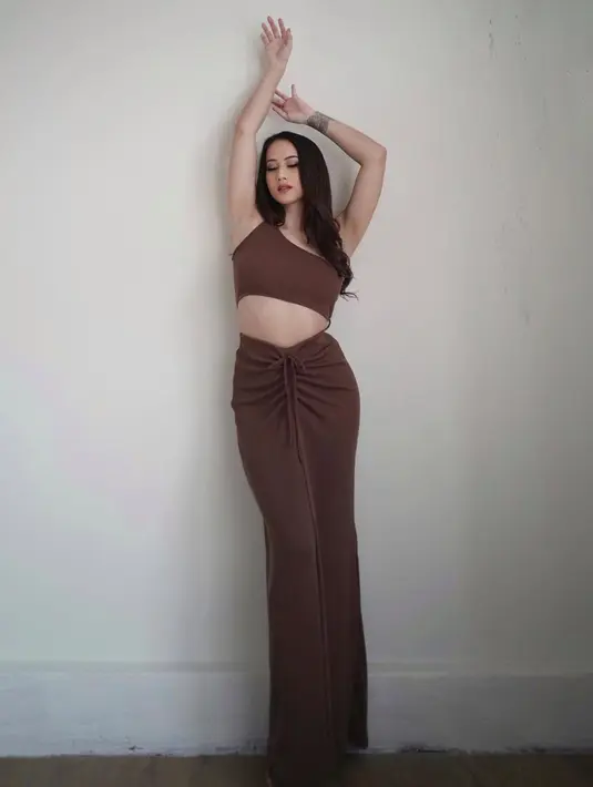 <p>Atau dress dengan potongan yang tidak biasa ini. Atasan crop top yang asimetris tanpa lengan tersambung dengan rok panjang dengan detail kerut di bagian tengah. Pemilihan warna cokelat juga sangat pas untuk kulit Janisaa yang cerah. Foto: Instagram.</p>