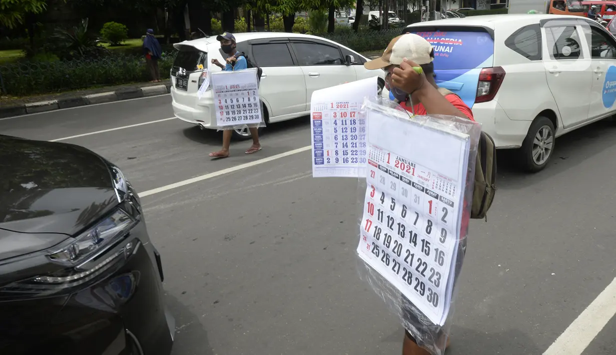 Pedagang menawarkan kalender tahun 2021 kepada pengguna jalan di perempatan Pondok Pinang, Kebayoran, Jakarta Selatan, Senin (7/12/2020). Jelang pergantian tahun, sejumlah pedangang mulai menjajakan kalender tahun 2021 dengan harga Rp 20 ribu-Rp 40 ribu tergantung ukuran. (merdeka.com/Dwi Narwoko)