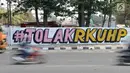 Mural bertulis '#TolakRKUHP' terpampang pada dinding di Jalan Pemuda, Rawamangun, Jakarta, Selasa (1/10/2019). Mural tersebut respons dari seniman Jakarta terhadap RUU KUHP yang dinilai mencederai tatanan demokrasi. (merdeka.com/Iqbal Nugroho)