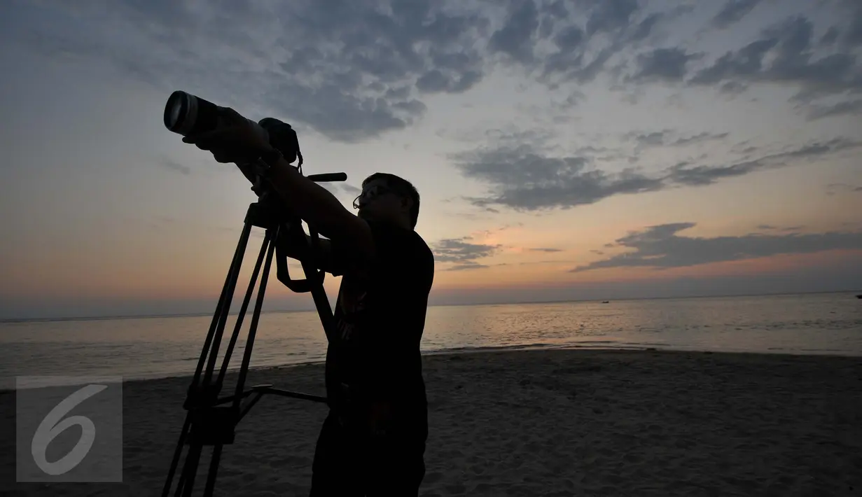 Seorang pria sedang mengabadikan Sunset di Pantai Sengigi, NTB (13/10/2015). Pulau Lombok terpilih sebagai pemenang dalam ajang internasional World’s Best Halal Travel Summit di Abu Dhabi, Uni Emirate Arab (UEA).(Liputan6.com/Gempur M Surya)