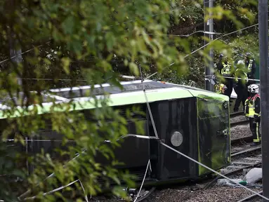 Petugas layanan darurat tiba di lokasi terbaliknya sebuah trem di sebuah terowongan di Croydon, London Selatan, Inggris, Rabu (9/11). Sebanyak tujuh orang tewas dan lebih dari 50 orang mengalami luka-luka akibat trem yang keluar jalur. (REUTERS/Neil Hall)