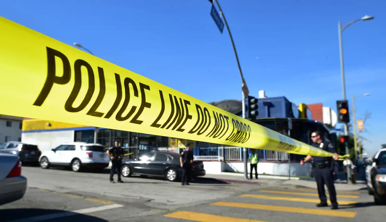 Petugas kepolisian menutup akses jalan menuju lokasi penembakan di sekolah menengah Salvador Castro, Los Angeles, Kamis (1/2). Belum jelas motif dari kejadian ini dan penyelidikan lebih lanjut masih dilakukan. (Frederic J. Brown/AFP)