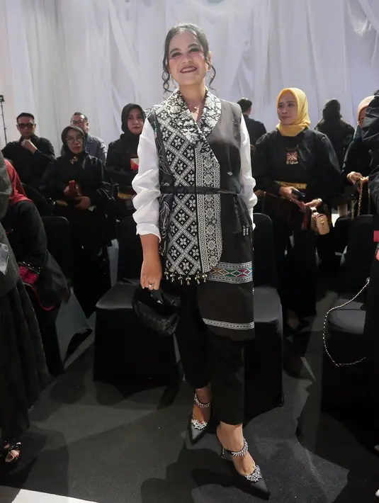 Kahiyang memadukan kemeja putihnya dengan vest tenun rancangan Mel Ahyar. Rambutnya ditata bergaya sanggul modern. [Fimela/Bambang E. Ros]