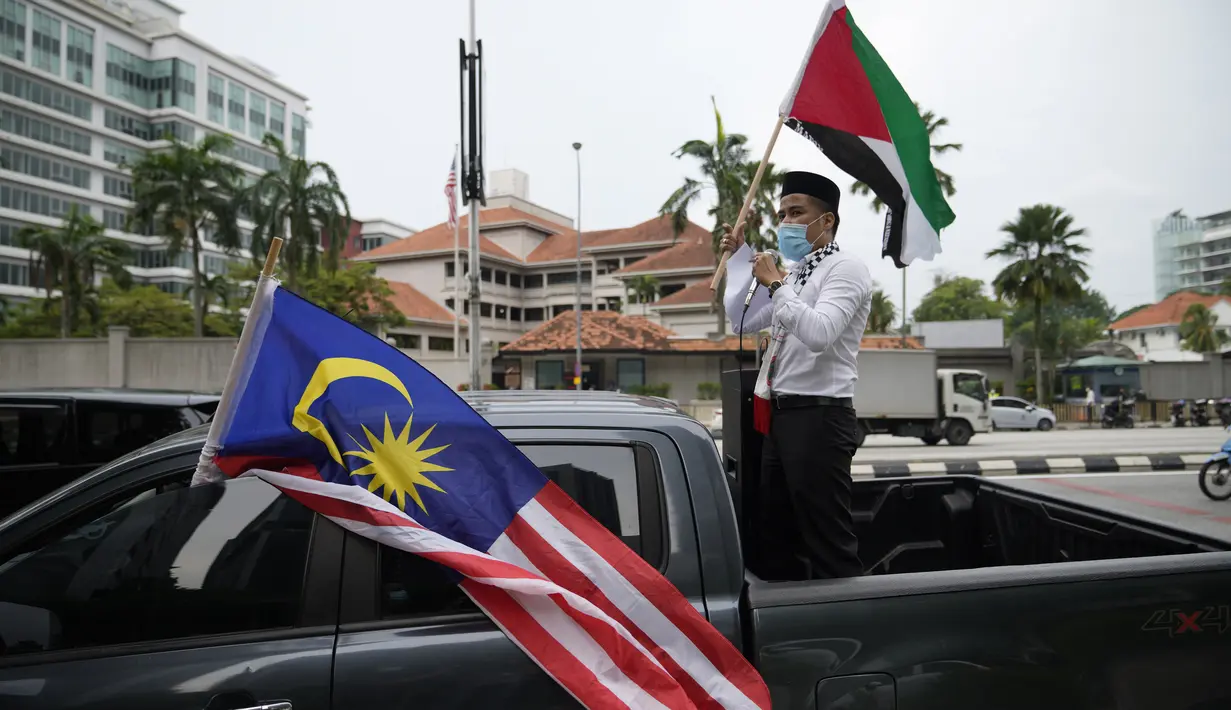 Warga Muslim membawa bendera Palestina saat konvoi protes menentang serangan Israel di Gaza di luar Kedutaan Besar Amerika Serikat di Kuala Lumpur, Malaysia, Jumat (21/5/2021).  (AP Photo / Vincent Thian)