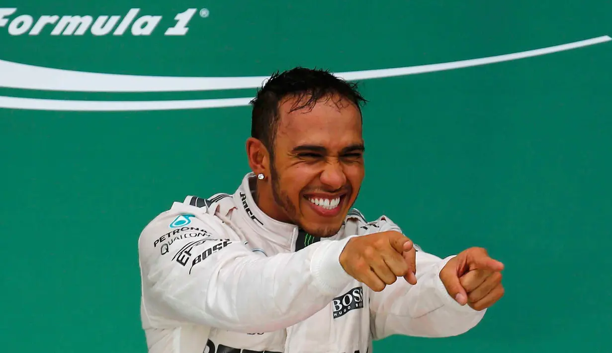 Pembalap Mercedes, Lewis Hamilton merayakan kemenangan usai merebut gelar Grand Prix F1 di Sirkuit The Americas, Minggu (25/10). Ini merupakan gelar juara dunia ketiga bagi Hamilton setelah sebelumnya diraih pada 2008 dan 2014. (REUTERS/Mike Stone)