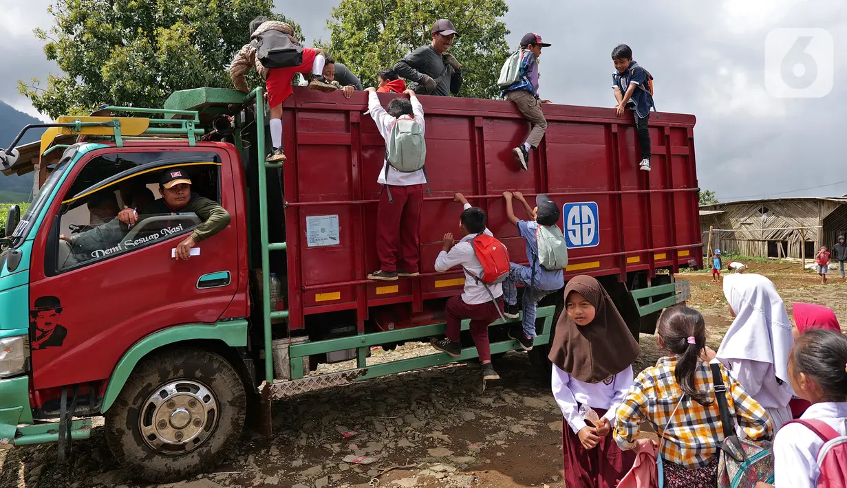 Siswa saat menaiki truk seusai belajar di SDN Cikoneng, Bogor, Selasa (30/3/2021). Untuk menuju sekolahnya di SDN Cikoneng, sebagian siswa harus menumpang truk, jalan kaki dan membawa kendaraan pribadi karena akses jalan yang sulit di daerah perbukitan perkebunan teh. (Liputan6.com/Herman Zakharia)