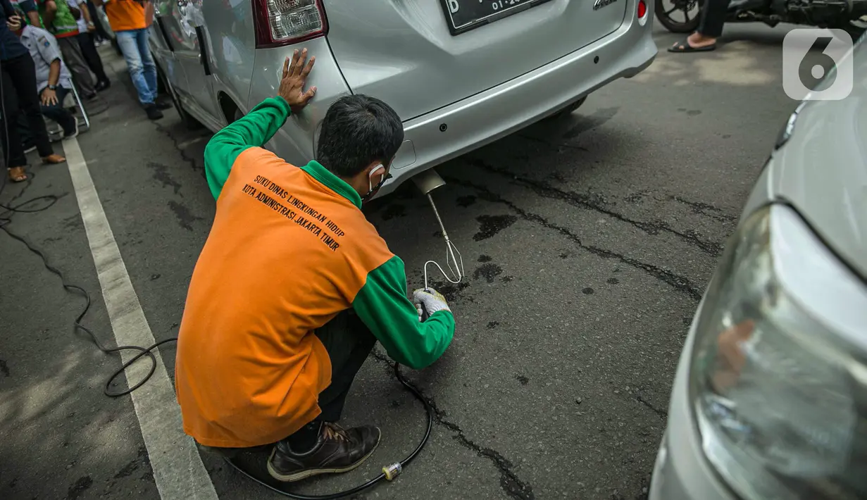 Petugas mengecek emisi gas buang kendaraan bermotor di Jakarta, Rabu (6/1/2021). Pengecekan yang diselenggarakan Dinas Perhubungan dan Kepolisian tersebut bertujuan untuk mengurangi polusi udara dari emisi gas buang kotor. (Liputan6.com/Faizal Fanani)