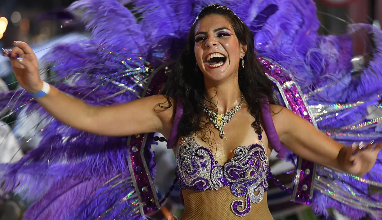 Anggota karnaval Uruguay, Comparsa, melakukan pertunjukkan tari selama parade karnaval Llamadas di Montevideo, Kamis (7/2). Para penari dengan menggunakan berbagai kostum menarik meriahkan parade tersebut di jalanan Montevideo. (PABLO PORCIUNCULA/AFP)