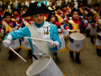 Seorang anak mengenakan seragam memimpin grupnya untuk memukul drum saat perayaan La Tamborrada di kota Basque San Sebastian, Spanyol (20/1). Acara ini bertujuan untuk menghormati santo pelindung mereka. (AP Photo / Alvaro Barrientos)